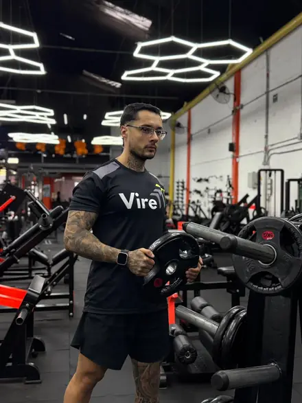 Juan Camilo Torres, VIRE ambassador, holding a plate at the gym